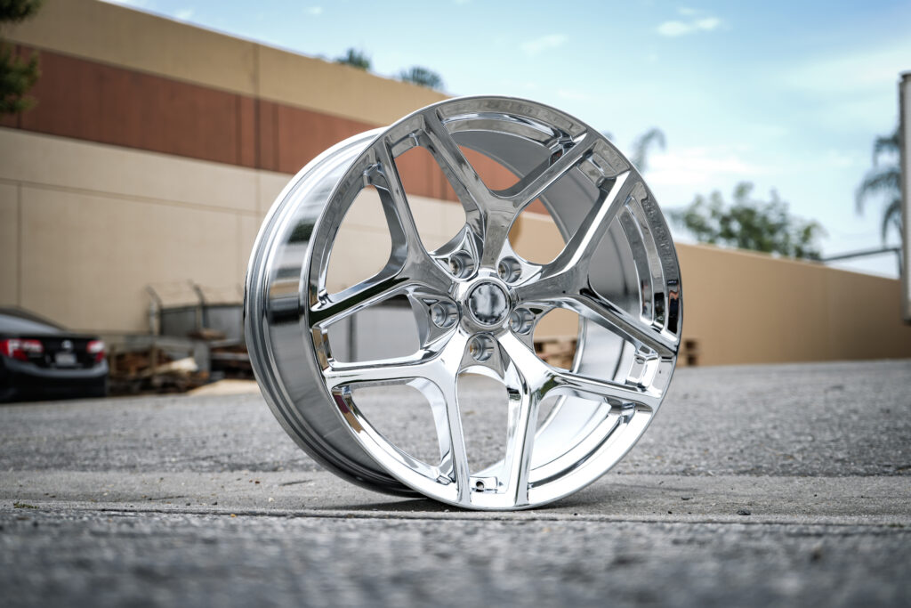 DSC00436 - Factory Reproductions FR27F replica wheel for corvettes in Chrome in an industrial setting on concrete.